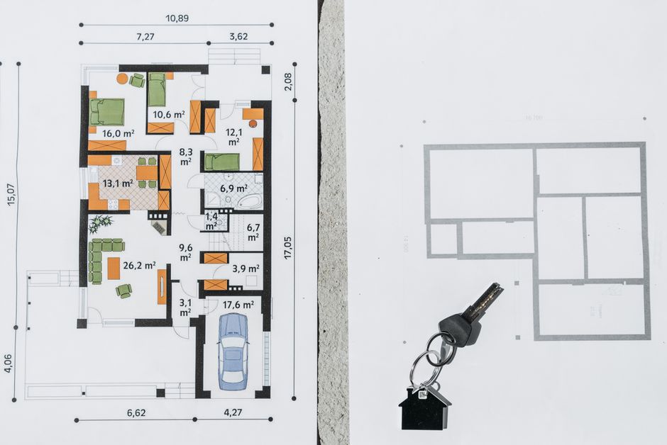 A set of house keys lies on top of architectural plans, symbolizing property investment, management, and the financial returns of strategic home improvements.