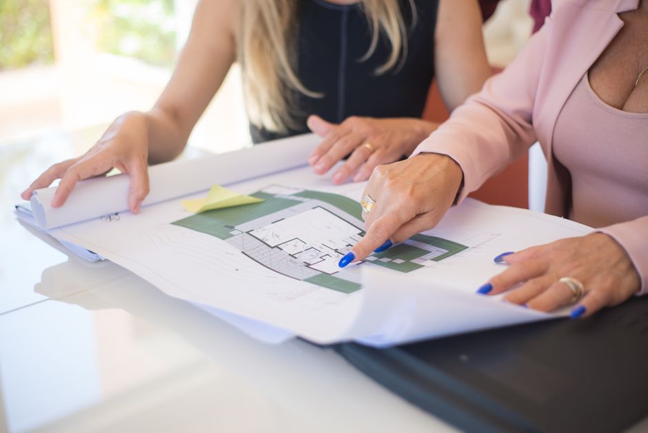 A well-dressed investor reviews architectural blueprints inside a stunning, high-end home, representing a strategic approach to specialty properties.